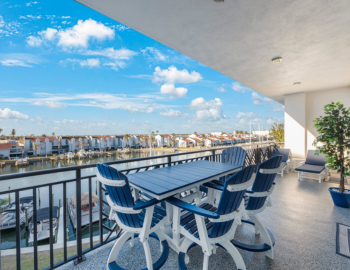 blue and white patio furnitue on a balcony overlooking a waterfront