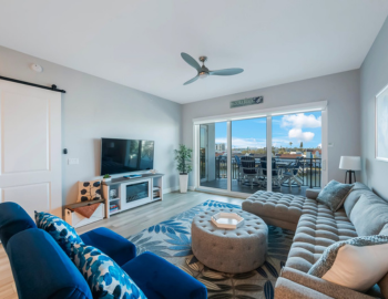 a living room with a sectional couch and love seat in madeira beach
